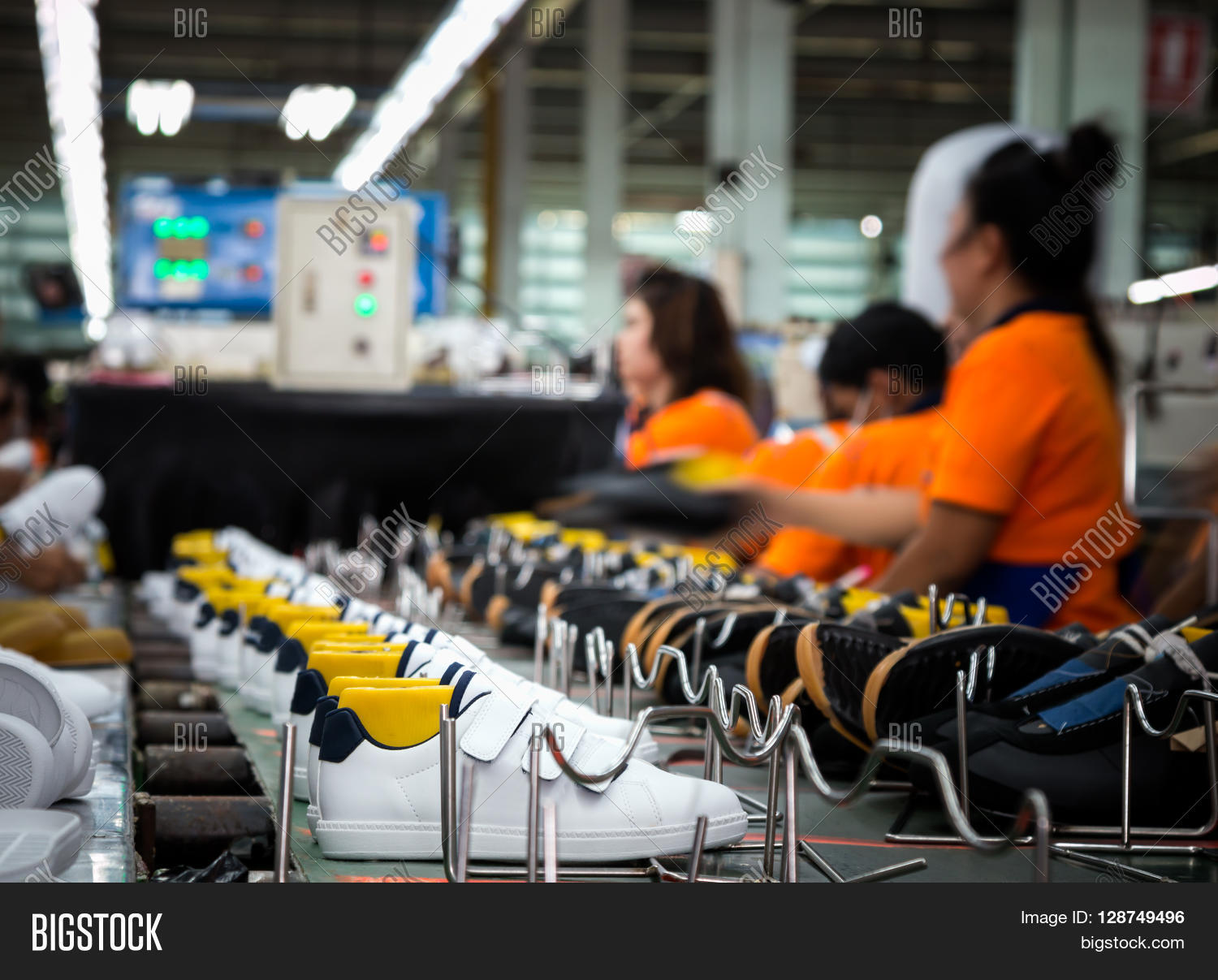worker making sport shoe in footwear production line Stock Photo