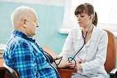stock photo of pressure  - doctor nurse measuring blood pressure of patient by phonendoscope in clinic hospital - JPG 
