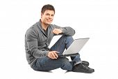 stock photo of guy  - Handsome guy working on a laptop and sitting on a floor - JPG 
