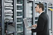 pic of network  - young engeneer business man with thin modern aluminium laptop in network server room - JPG 