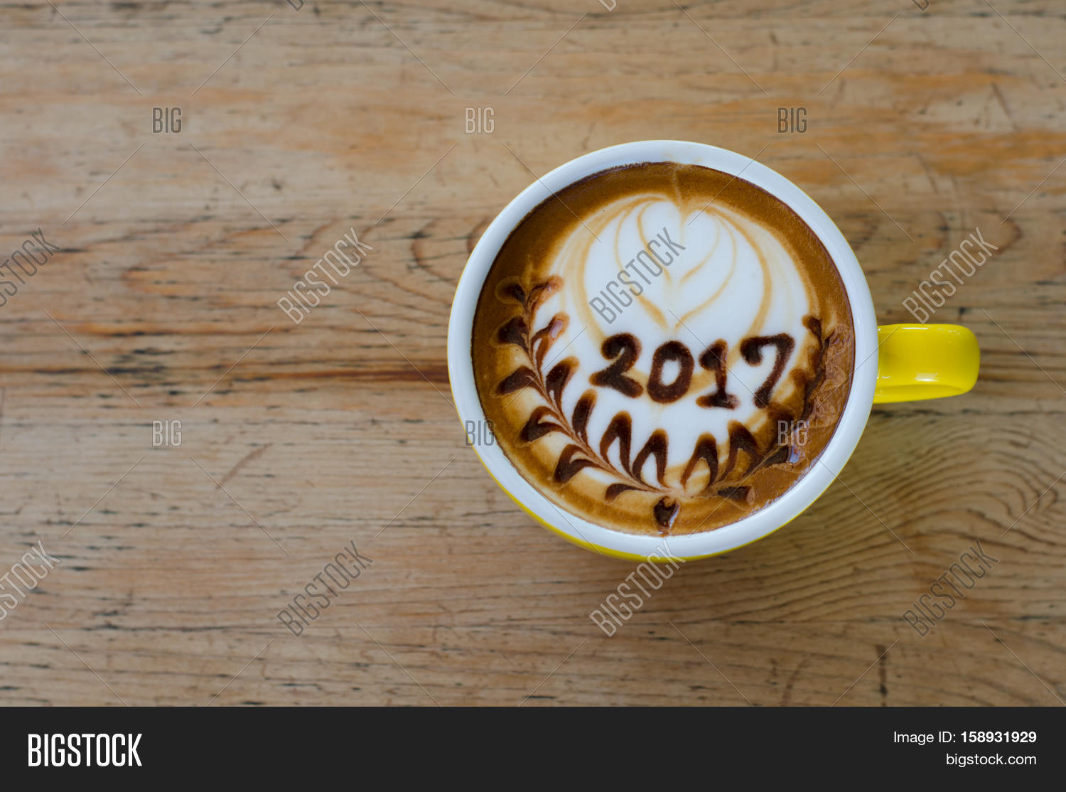 hot coffee with foam milk art 2017 on wooden table stock photo hot coffee with foam milk art 2017 on wooden table stock photo