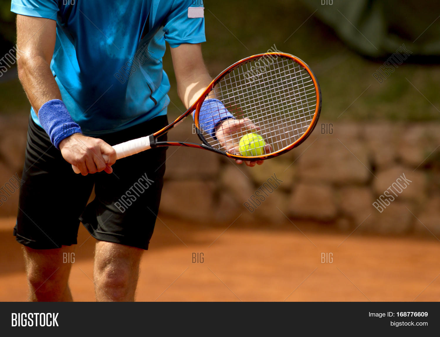 A tennis player prepares to serve a tennis ball during a match Stock