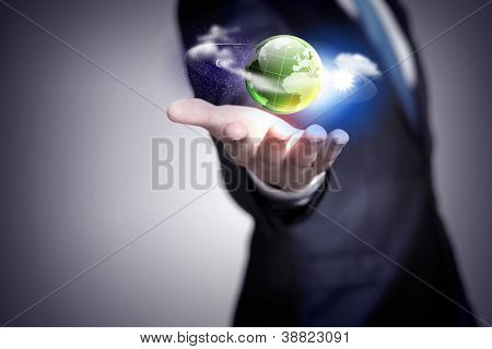 Picture or Photo of Human hand holding our planet earth glowing