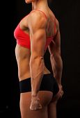 stock photo of fitness  - Female fitness bodybuilder posing against black background - JPG 