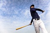 stock photo of competition  - baseball player taking a swing with cloud background - JPG 