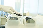 foto of silicon  - The hand of a researcher in a cleanroom picking up a silicon wafer commonly used in the semiconductor industry to make electronic devices
 - JPG 