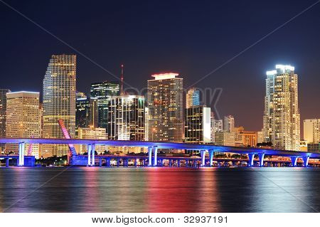 Picture or Photo of Miami city skyline closeup at dusk with urban skyscrapers and bridge over sea with reflection