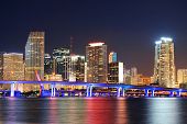 image of reflection  - Miami city skyline closeup at dusk with urban skyscrapers and bridge over sea with reflection - JPG 