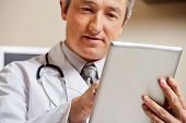 pic of males  - Close up of mature male doctor using digital tablet - JPG 