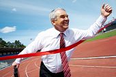 picture of business people  - Photo of happy mature businessman crossing finish line during race - JPG 