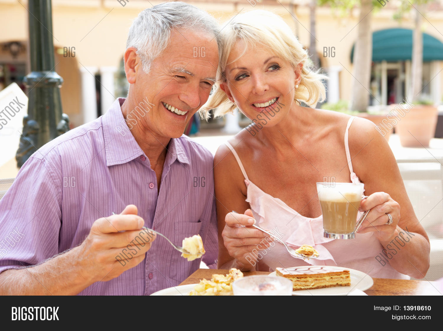 Senior Couple Enjoying Coffee And Cake In Cafe Stock Photo & Stock