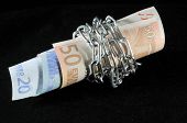 foto of money  - Money in chains that represents the crisis on a black background - JPG 