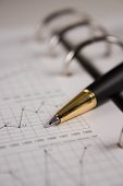 stock photo of wall street  - Stock chart with a black pen pointing a graph - JPG 