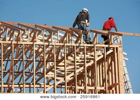 Picture or Photo of Unidentifiable construction workers work on framing a building