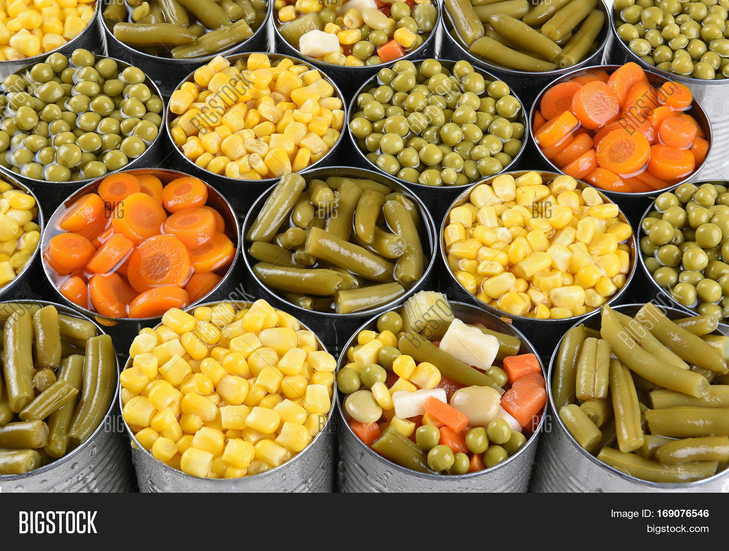 Closeup shot of cans of vegetables. Corn, Peas, Green beans, carrots in