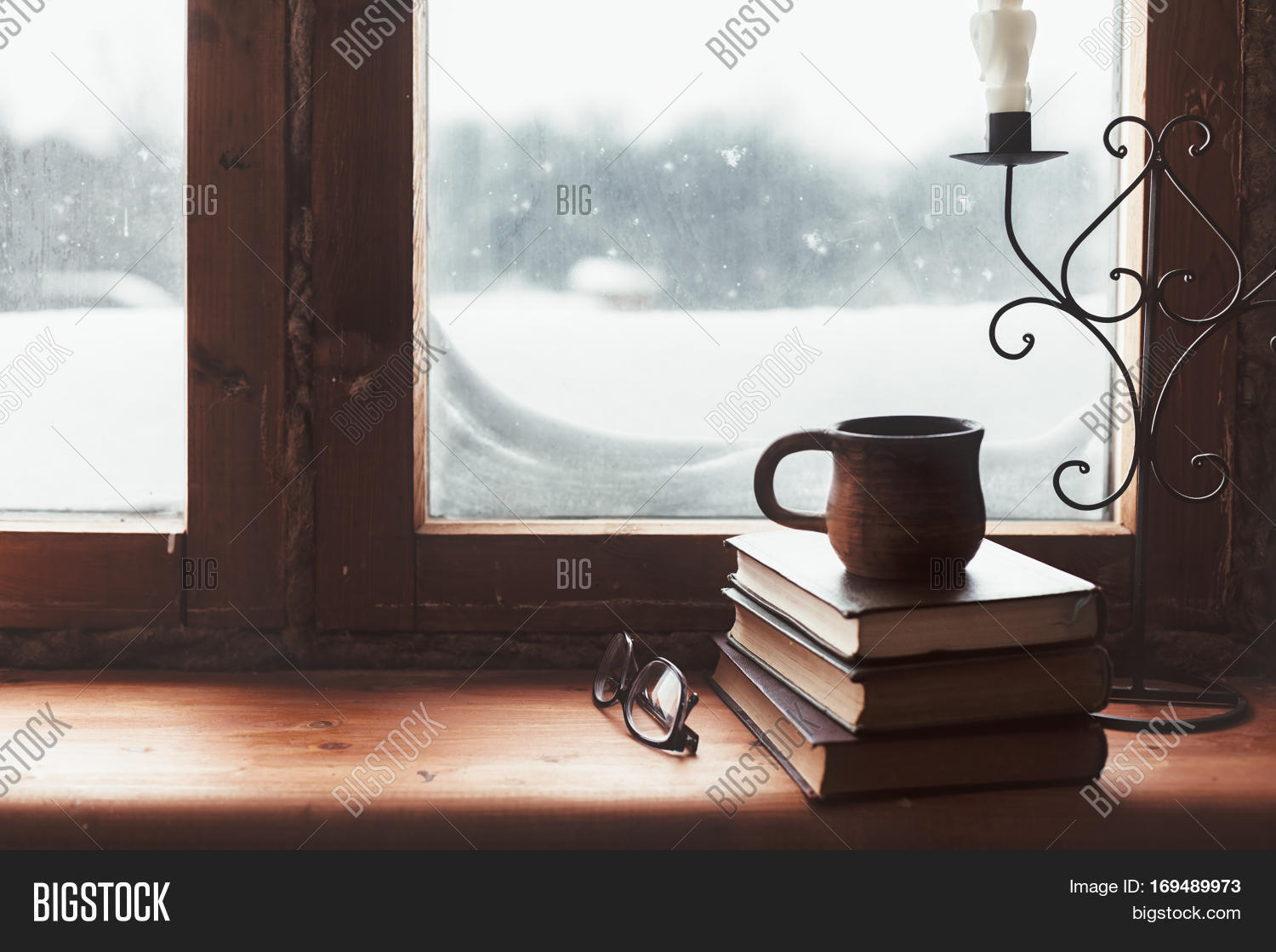 Warm and comfy winter concept. Book, cup of tea and candlestick on