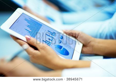 Picture or Photo of Businesswoman hands with touchpad while learning situation on the market