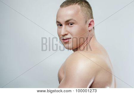 Bodybuilder in oil on a gray background