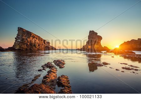 Dramatic Sunrise With Mist On The Beach With Rocks