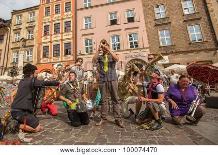KRAKOW, POLAND - JUL 12, 2015: Participants at the annually (July 9-12) 28th International Festival of Street Theatres - Orchestre International du Vetex (Belgium/France) in the Main Square of Krakow.