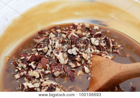 Wooden Spoon Stirring Pecan Nuts Into Pie Filling