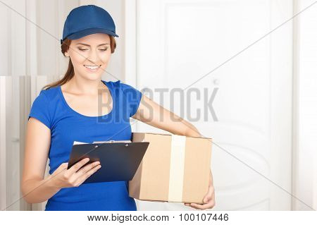 Nice deliverywoman standing near door
