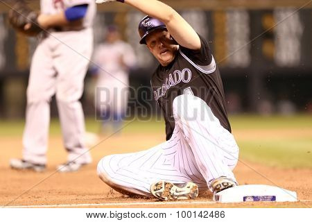 DENVER-AUG 21: Colorado Rockies catcher Nick Hundley slides into third base during a game against the New York Mets at Coors Field on August 21, 2015 in Denver, Colorado.