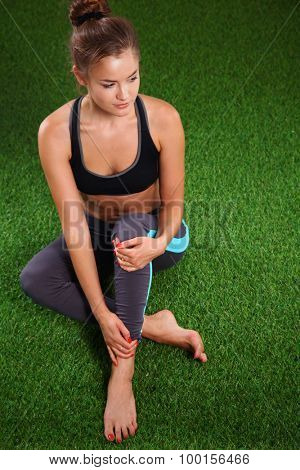 Beautiful young woman relaxing after exerscises on the grass 