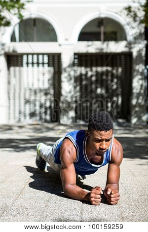 A muscular man on plank position on a sunny day