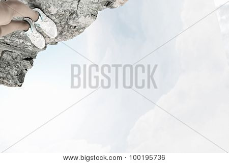 Close up of woman legs standing on the edge of rock