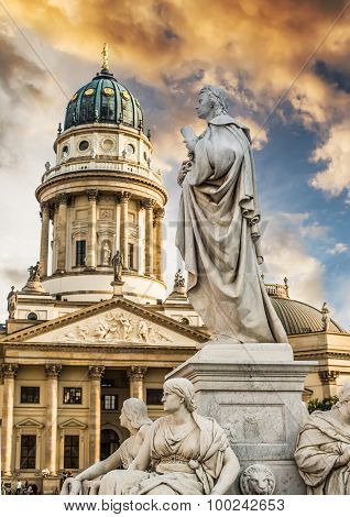 Beautiful squares in Berlin, the Gendarmenmarkt, marble statue of German poet Friedrich Schiller at sunset