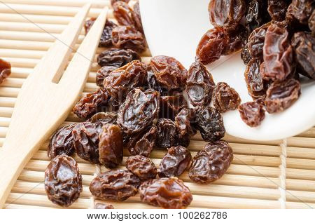 Raisin On White Cup On Wooden Spoon Fork