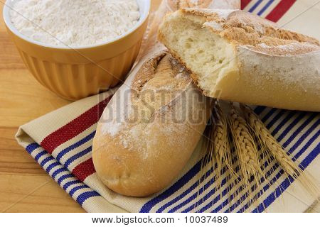 Läckra Crusty Baguette bröd på en röd vit och blå handduk