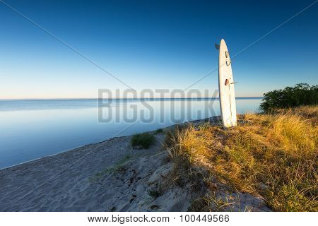 Surfing Board Pounded In Sand On Sea Shore