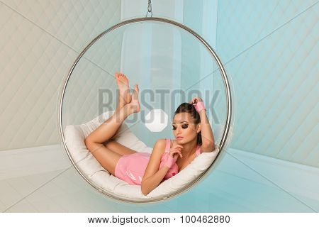 Sexy Girl Lying And Rests In A Transparent Glass Chair