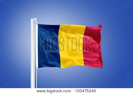 Flag of Chad flying against a blue sky.