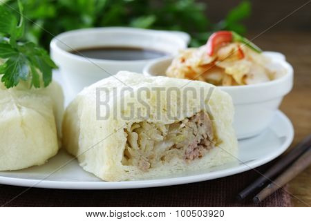 Korean steam meat pies (pigodi) served with soy sauce and kimchi
