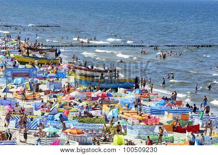 REWAL - AUGUST 13: Tourists enjoy the sunny weather and relaxing on the Baltic sea beach on 13 August 2015 in Rewal, Poland.