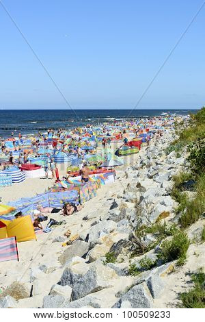 REWAL - AUGUST 13: Tourists enjoy the sunny weather and relaxing on the Baltic sea beach on 13 August 2015 in Rewal, Poland.