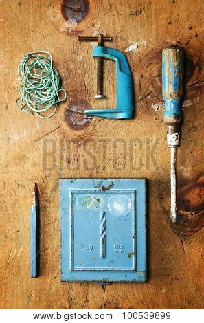 Vintage wood table with drill, screwdriver, clamp, plummet and rope.