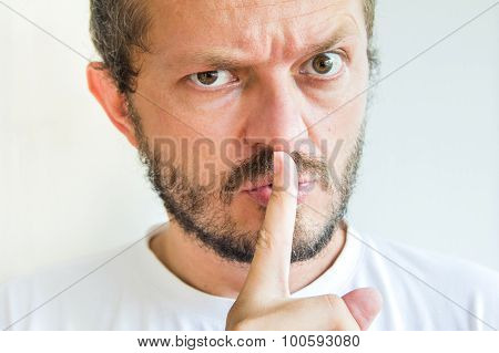 Bearded man making silence gesture