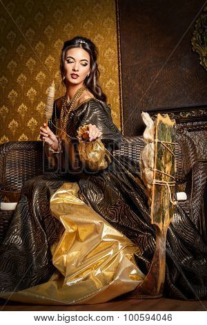 Beautiful fairy girl like a Snow White in a beautiful lush dress spins on the spinning wheel.  Renaissance. Barocco. Fashion. Fairy tale.