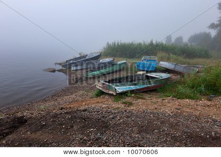 Gamla båtar vid floden dimmig av sibiriska floden Enisey