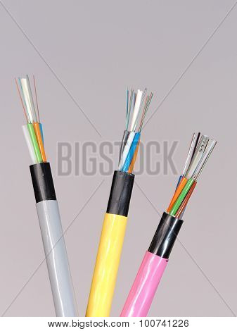 Different colored fiber optic cable ends with stripped jacket layers and exposed colored fibers