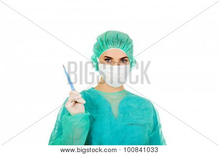Young female cardiologist surgeron holding heart and scalpel.