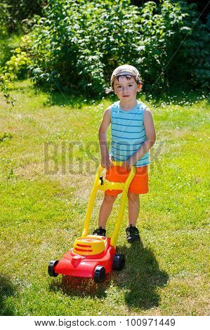 Happy Small Boy Help With Gardening With His Lawn Mower