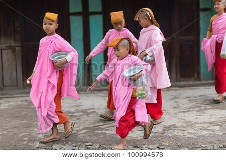 MANDALAY,MYANMAR,JANUARY 17, 2015 : A group of young Buddhist nuns is walking in the streets of Mandalay, Myanmar (Burma).