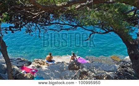 omen bathers swimming from the rocks at lapad bay