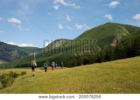tourists with backpacks go in the mountains