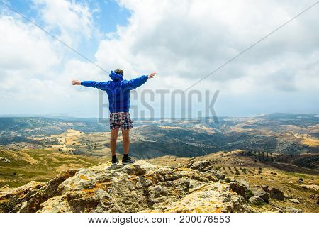 Happy man gesture of triumph with hands in the air on the mountain